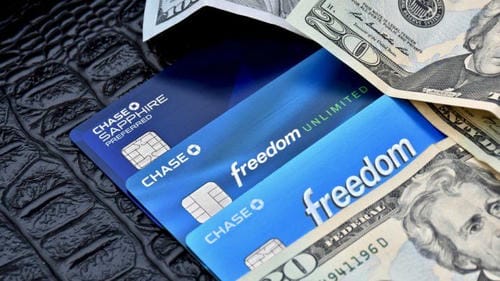 Three Chase credit cards (Chase Sapphire Preferred, Freedom Unlimited, Freedom) partially covered by US dollar bills.