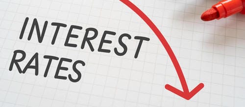 The text "INTEREST RATES" with a downward red arrow, symbolizing falling interest rates.